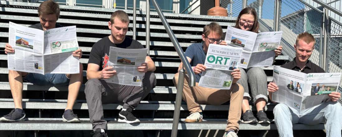 Studierende beim lesen der UBT aktuell